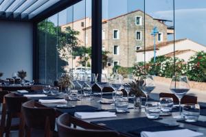 a table with wine glasses on it in a restaurant at Auberge Kallisté - Eco Label in Porto Pollo