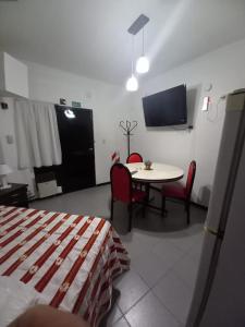 Habitación con mesa, sillas y TV. en Apartamentos Willy - en Zona Residencial con Estacionamiento en Mendoza