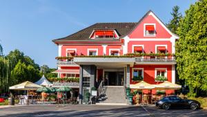 una casa roja con un coche aparcado delante de ella en Hôtel Restaurant Kuentz, en Wittersdorf