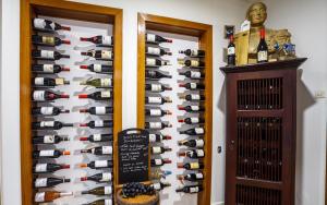 een wijnkelder met een muur van wijnflessen bij Hôtel Restaurant Kuentz in Wittersdorf