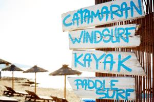a bunch of signs on a beach with umbrellas at Insotel Hotel Formentera Playa in Playa Migjorn