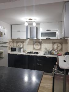 a kitchen with white cabinets and a black counter top at Casa Mara in Dorna Arini