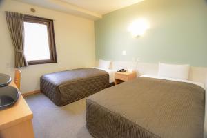 Habitación de hotel con 2 camas y ventana en Kamata Inn Social, en Tokio