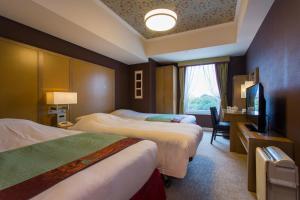ein Hotelzimmer mit 2 Betten und einem TV in der Unterkunft Hotel Monterey Akasaka in Tokio