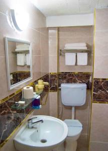 a bathroom with a sink and a toilet and a mirror at Yunus Hotel in Gaziantep