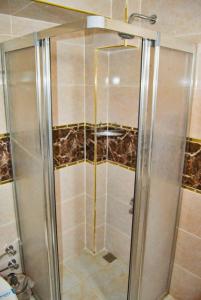 y baño con ducha y puerta de cristal. en Yunus Hotel en Gaziantep
