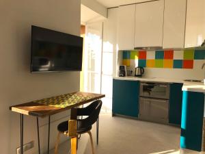 uma cozinha com uma mesa e uma cozinha colorida em Résidence du Louvre em Menton