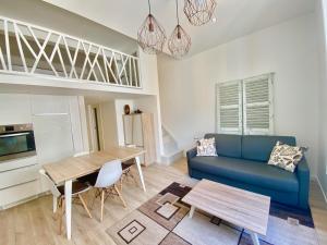 - un salon avec un canapé bleu et une table dans l'établissement Studio La Pietonne, à Menton