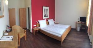 a bedroom with a bed with a red wall at Altstadt Hotel in Potsdam