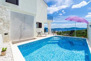 a villa with a swimming pool and an umbrella at Villa Sofija Dubrovnik & Peljesac Region in Slano