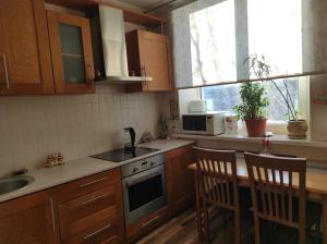 a kitchen with wooden cabinets and a sink and a table at NarvaCenter in Narva