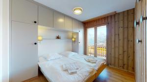 - une chambre avec un grand lit blanc et un balcon dans l'établissement Cozy apartment in Veysonnaz, close to the slopes of the 4 Valleys, à Veysonnaz