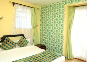 een slaapkamer met een bed en een groene en witte muur bij Davis Court in Nyeri