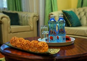 a table with two bottles of water and a plate of food at Davis Court in Nyeri