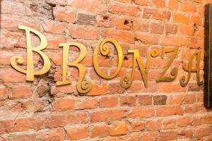 a brick wall with a sign on a brick wall at Bronza Hotel in Saint Petersburg