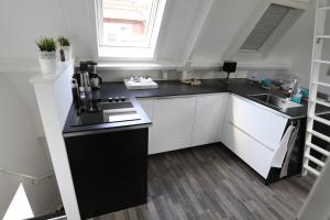 a kitchen with white cabinets and a black counter top at Appartement Klein Waldeck in Velp