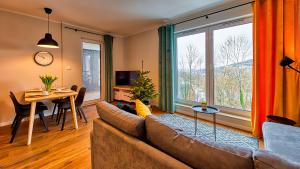 ein Wohnzimmer mit einem Sofa und einem Tisch in der Unterkunft Apartament Pod Stogiem Izerskim - 5D Apartamenty in Świeradów-Zdrój