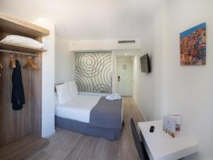 Habitación de hotel con cama y TV en Pasarela en Sevilla