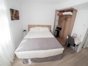 Cama en habitación pequeña con escritorio y cama en Pasarela en Sevilla