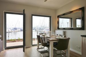 a dining room with a table and chairs and a window at Strandresort Heiligenhafen Strandresort 47 in Heiligenhafen