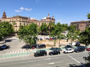 un estacionamiento con autos estacionados frente a un edificio en Pasarela, en Sevilla