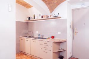 Una cocina con gabinetes blancos y un fregadero. en Restart Accommodations Rosa, en Roma