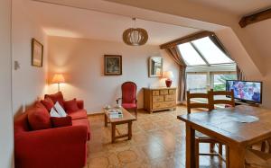 sala de estar con sofá rojo y mesa en Gite du Clos Champagnac en Chailly-sur-Armançon