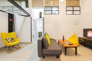 a living room with a couch and a chair and a tv at Ever House - ALCALA LOFT in Madrid