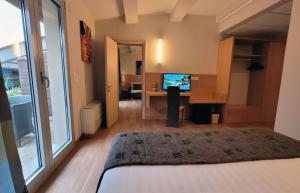 a bedroom with a bed and a desk with a television at Relais Bellaria Hotel & Congressi in Bologna