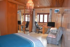 um quarto com uma cama, uma secretária e cadeiras em studio indépendant dans maison à la campagne em Égliseneuve-près-Billom