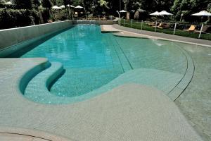 a swimming pool with blue water in a resort at Relais Bellaria Hotel & Congressi in Bologna