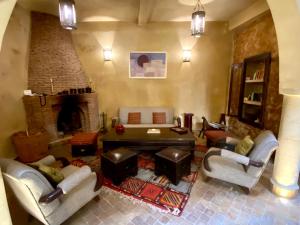 ein Wohnzimmer mit Stühlen und einem Kamin in der Unterkunft Villa Allun Essaouira in Essaouira