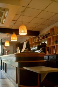 a restaurant with a counter with lights above it at HOSTEL Les Bois Verts - Les Herbiers in Les Herbiers