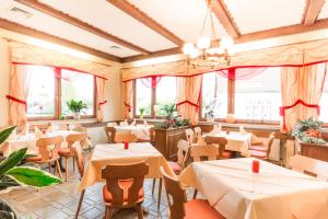 a restaurant with tables and chairs and windows at Hotel- Restaurant Zum Hirsch in Großenlüder