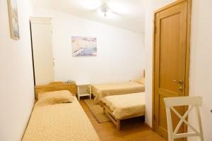 a small room with two beds and a door at Country house Poljana Ubinskaja in Ubinskaya