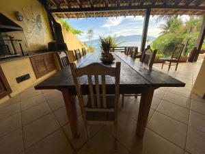 a wooden table in a kitchen with a table and chairs at Casa na praia in Mangaratiba