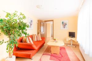 ein Wohnzimmer mit einem roten Sofa und einem Tisch in der Unterkunft Hotel- Restaurant Zum Hirsch in Großenlüder