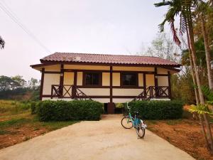 uma pequena casa com uma bicicleta estacionada em frente em RS Phong Riverside Resort em Khon Kaen