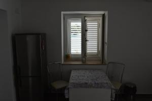 a table and chairs in a room with a window at L´odore del mare in Preko