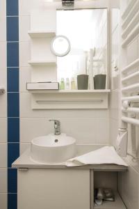 a white bathroom with a sink and a mirror at Xendala Panzió in Balatonakarattya