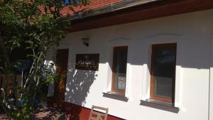 a building with three windows on the side of it at Nádas Panzió in Tiszafüred