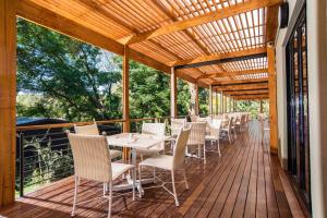 a wooden deck with tables and chairs on it at Sparkling Water Hotels & Spa in Rustenburg