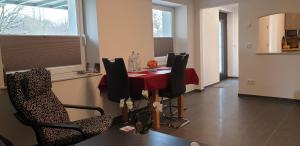 a dining room with a red table and chairs at Souterrainwohnung im Grünen in Witten