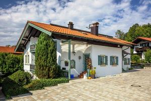 een wit huis met een oranje dak bij Landhaus Pröchel in Reit im Winkl