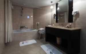 a bathroom with a tub and a sink and a shower at The Sindbad in Hammamet