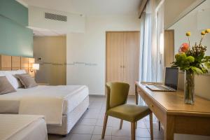 Habitación de hotel con cama y escritorio con ordenador en Ionian Plaza Hotel en Argostoli