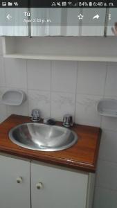 ein Waschbecken auf einer hölzernen Arbeitsplatte in der Unterkunft Los Cuatro Corazones in Villa Gesell