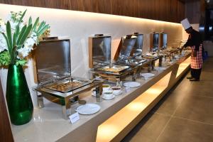 a buffet line of food on display in a restaurant at Hotel Palazzo Prime in Tezpur