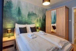 シュクラルスカ・ポレンバにあるApartamenty Sun Seasons 24 - Złoty Widokのベッドルーム1室(壁に絵画が描かれた大型ベッド1台付)