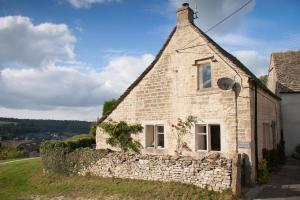 an old stone house with a stone wall at Traditional Cotswold Stone Peaceful Cottage with stunning views in Stroud